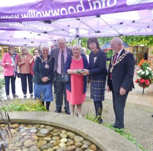 The Lord-Lieutenant and Vice Lord-Lieutenant placing a memory stone engraved with The Queen's name into the memory pool at Willow Wood Hospice